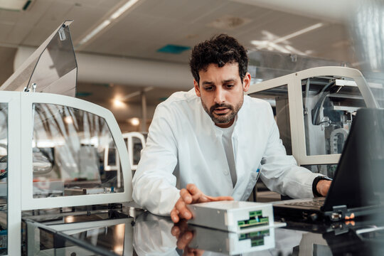 Scientist analyzing information and monitoring machine