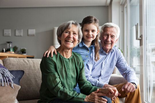 Family portrait of grandparents and their granddaughter at home