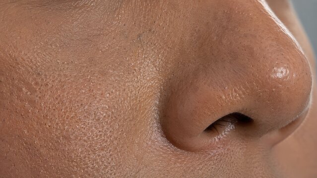 Close-up macro image of natural human face skin texture showing pores on nose and cheek