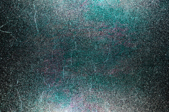 Black dark indigo blue green orange glitter shiny abstract background for design. Twinkling glow stars effect. Fantastic, fantasy. Like outer space, night sky, universe. Grain, rough surface.