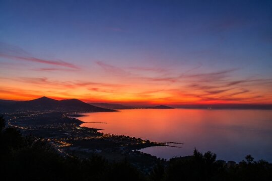 The last vibrant streak of sunset light lingers on the horizon after dusk, serene sky.