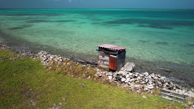 Drone orbit of a lone ranchito, rustic fishing hut on a a remote Caribbean island in the Los Roques Archipelago, Venezuela