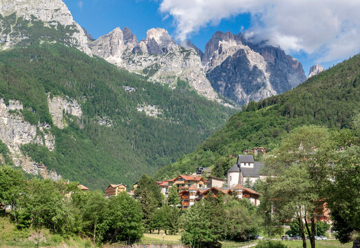 view on Molveno village in Dolomites in Italy and large rocky peak mountain background under sky