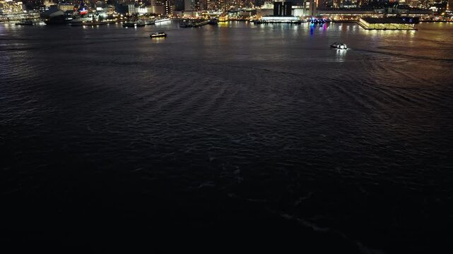Night establishing overview of Hell's Kitchen and Hudson Yards skyline in Manhattan, drone