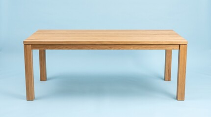 Fototapeta premium Minimalist rectangular wooden dining table made of light oak, featuring clean lines and a modern design, isolated against a solid light blue background.