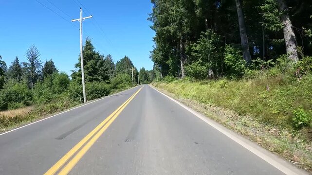 4K smooth action camera driving  footage from a hood mounted driver's POV along a scenic countryside road in Oregon, USA with forest, rural homes, fields and Pacific Northwest scenery