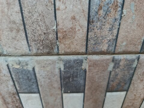 oA close-up shot of a textured stone wall with distinct vertical patterns and weathered brown and grey tones.