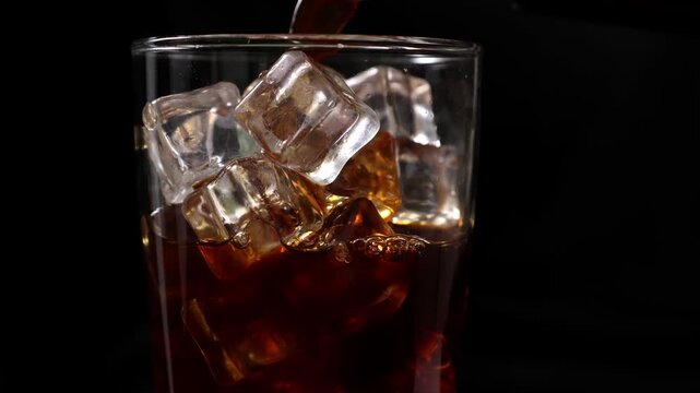 Pouring iced coffee into a glass with ice cubes
