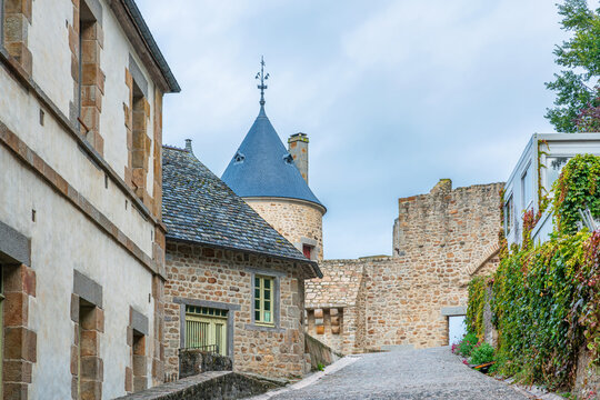 Medieval cobblestone street with historic stone buildings and tower inside Mont Saint-Michel in Normandy, France. Old town architecture, heritage tourism, European villages and cultural travel