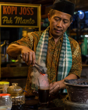 Vendor preparing kopi joss charcoal coffee at Yogyakarta night stall