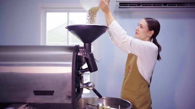 Female roaster pouring green coffee beans into roasting machine