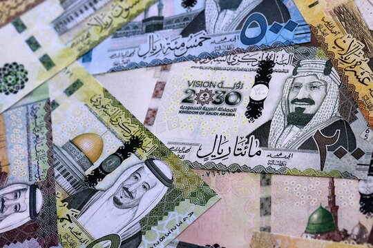 Saudi riyal money bills pile on table. Saudi Arabia banknotes of SAR currency close up.