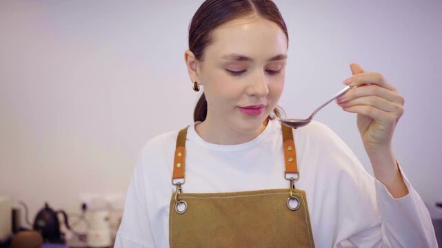 Coffee master performing coffee cupping procedure in roastery cafe