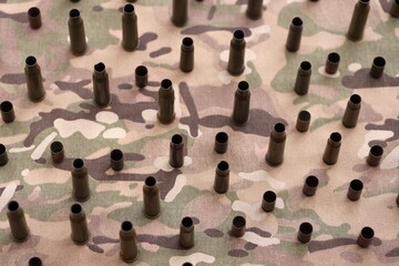 Fototapeta premium Big amount of shells cartridges from assault rifle bullets on old camouflage fabric