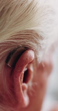 Back, old man and ear in home with hearing aid, auditory support and implant prescription for audio. Closeup, deaf and senior person with disability, cochlear device and medical innovation for sound