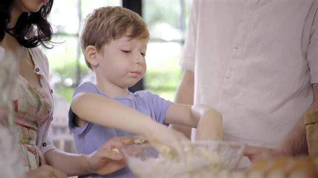 Caucasian family parent and son kneading dough for pizza or cookies