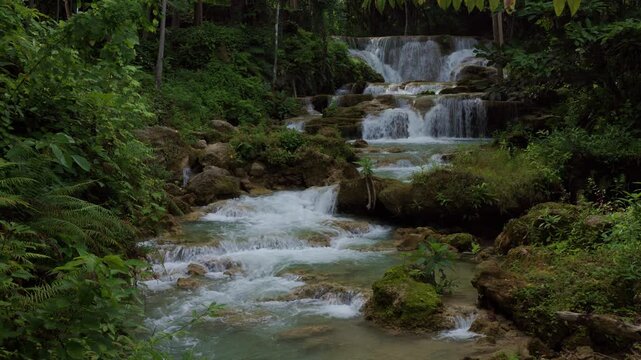 Crystal Clear Waterfall Cascading Over Limestone Tiers Within Lush Tropical Jungle At Huai Mea Khamin National Park In Thailand