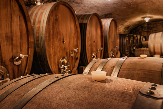Wine barrels aging in a traditional underground cellar, showcasing the winemaking process and a rustic, authentic atmosphere