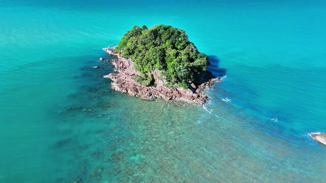 Cinematic drone footage of Punggur Island surrounded by crystal turquoise sea, granite shoreline, coral flats and untouched tropical landscape
