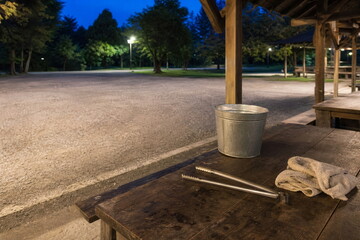 Naklejka premium 夜の公園管理に備えた水バケツと長い火ばさみ