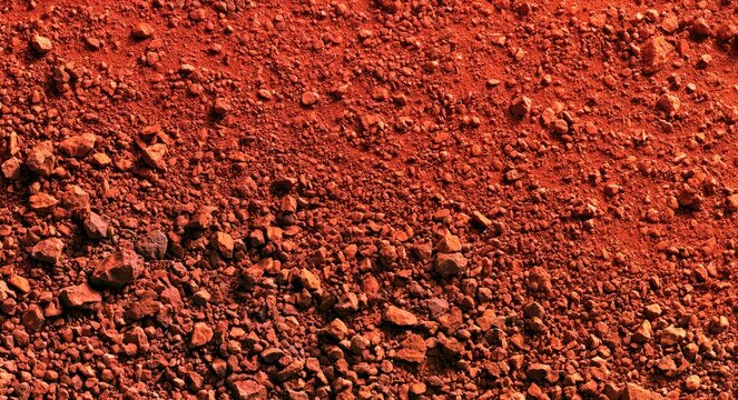Reddish, rocky surface with granular texture and scattered small stones