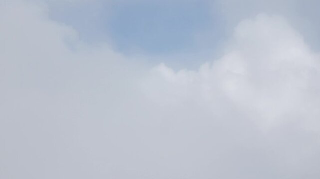 Aerial view above the clouds and sky inspiration concept in cinematic breathtaking aerial flying over white fluffy cloudscape in high altitude sky with fresh clean air and blue skies on background.