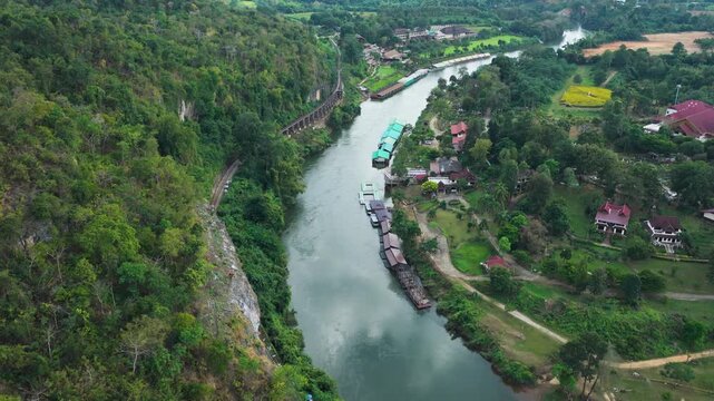 Krasae River beside cliff railway historic site and lush forest in Kanchanaburi, drone
