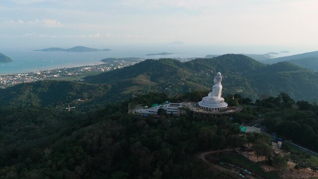 Wide aerial of Big Buddha above Phuket hills and coastal islands, drone approach