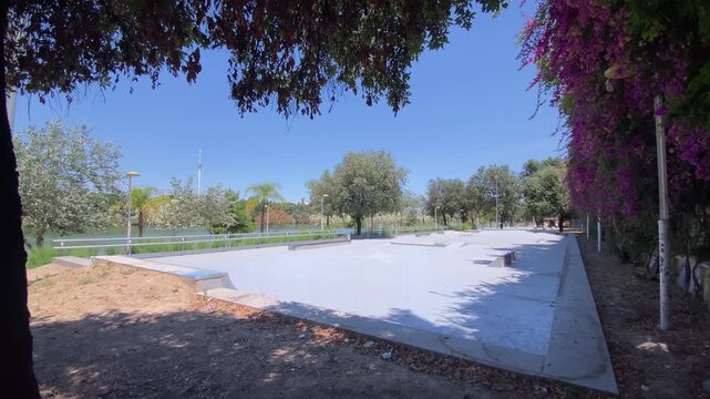 Urban skatepark promoting youth culture and outdoor activity. Concrete ramps and obstacles surrounded by lush vegetation