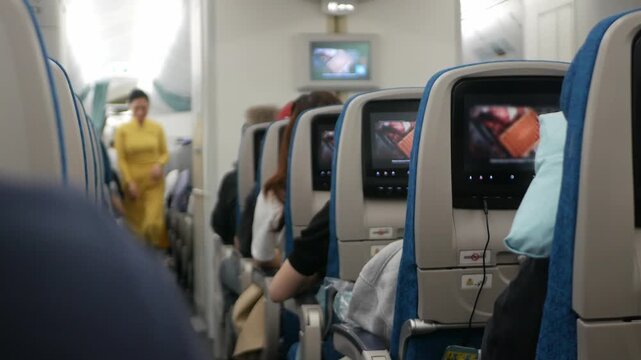 interior view to airplane seat with personal screen entertainment on every seat full with passenger ready for departure traveling, aircraft airplane cabin wide body seat full with passenger