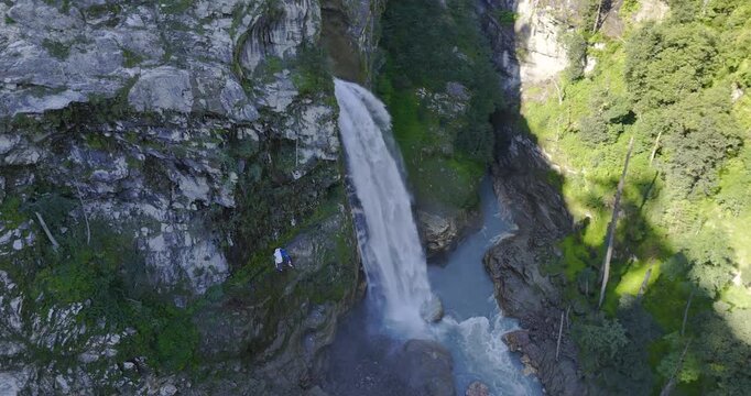Annapurna Circuit, Nepal, aerial orbit shot showing Danaque waterfall cascading down a steep rock cliff into the Marsyangdi River in the Manang region.