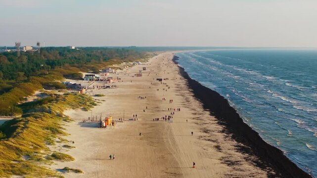 Drone yaws left revealing the long sandy Liepaja Beach and Baltic Sea coastline