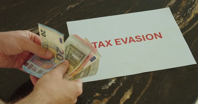 Hands counting money beside a tax evasion message, representing financial crime, illegal activity and tax avoidance risks.