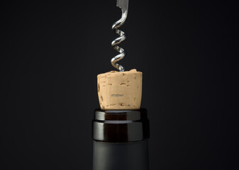 Obraz premium Uncorking a bottle of red wine close up, Opening wine bottle with corkscrew on dark background