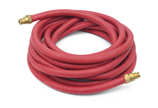 Red flexible garden water hose coiled on white background with watering flexible irrigation equipment outdoors