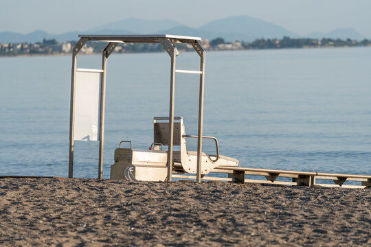 Sea track system on accessible beach in Greece, for people with mobility disabilities to independently enter sea using automated rails and transfer chair. Accessibility design, barrier free recreation