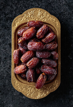Dates fruits on black stone table.