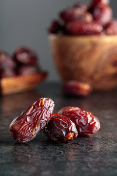 Dried dates fruit on a black table.