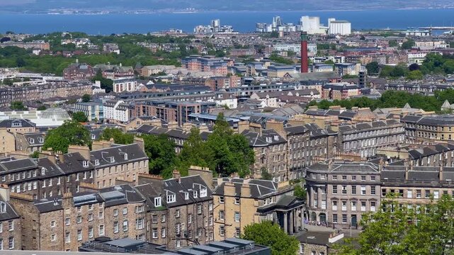 Panoramic view of Edinburgh, Scotland from Calton Hill, historic city skyline, rolling hills and the Firth of Forth in the distance, famous European travel destination