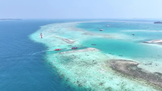 Aerial view of turquoise ocean waves breaking on white sand beach. Stunning coastal shoreline with clear blue water and natural surf patterns