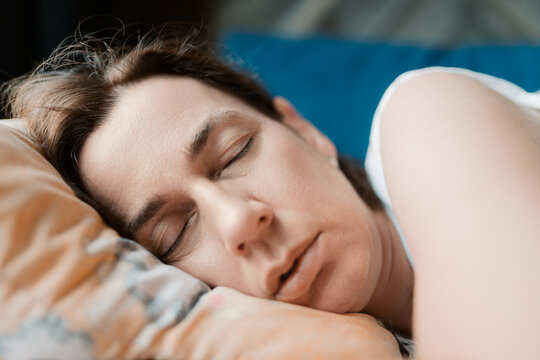 Close Up Face Portrait of a Serene Caucasian Woman Sleeping Peacefully in Bed with Closed Eyes and Head Resting on a Pillow