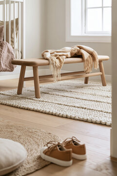 Softly blurred leather shoes in foreground, low oak bench with folded throw in Scandinavian kids room, soft afternoon light illuminating the space