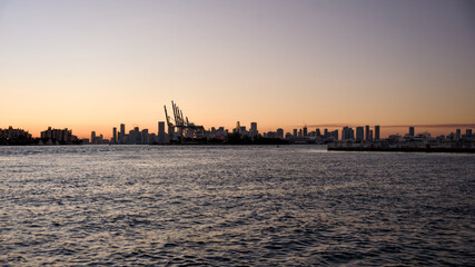 Fototapeta premium The Miami downtown skyline glows at sunset with calm water in the foreground
