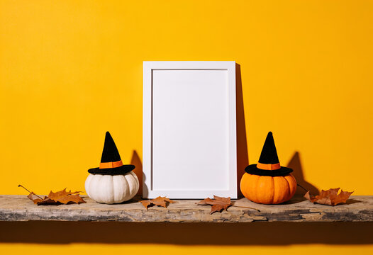 Halloween themed pumpkins with witch hats and empty frame on wooden shelf
