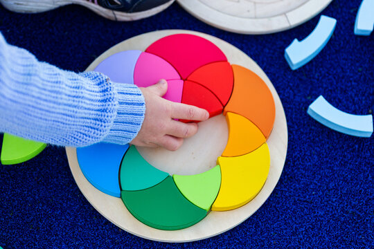 Little girls hands doing colourful puzzle game at preschool