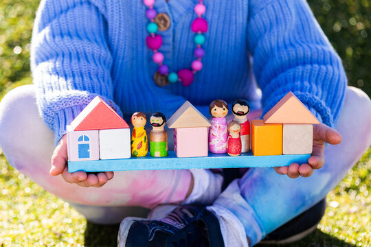 Housing affordability and family concept shown with child holding blocks of coloured homes