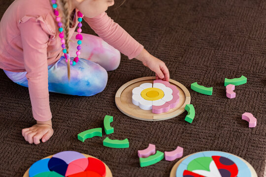 kid playing with colourful wooden puzzle motor skills developmental toy