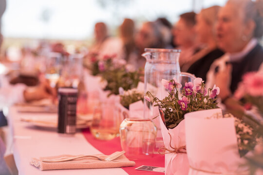Table setting with flowers, and women in the background
