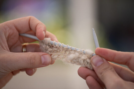 Hands displaying a small piece of knitting