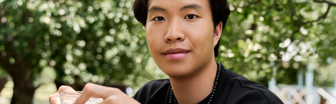 Young man enjoys relaxation at garden cafe during a sunny summer day